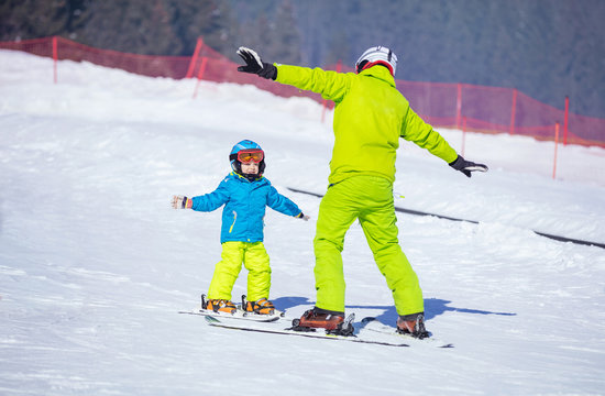 Instructor teaching little boy to ski
