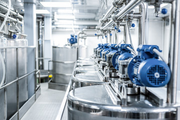 Obraz na płótnie Canvas Rows of blue electric motors on tanks for mixing liquids.