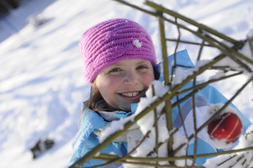 kleines M&auml;dchen im Schnee spielt mit Stern