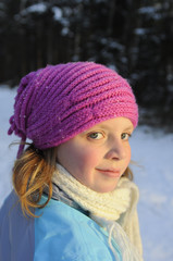 kleines Mädchen mit Mütze im Winter lächelt in die Kamera