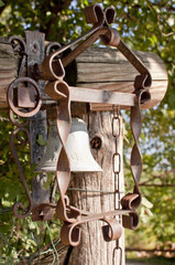 Bell with a metal frame on a wooden pole