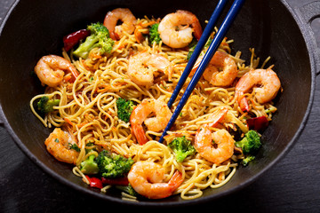 Stir fried noodles with shrimps and vegetables in a wok