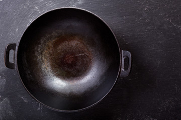 empty wok pan on a dark table - obrazy, fototapety, plakaty