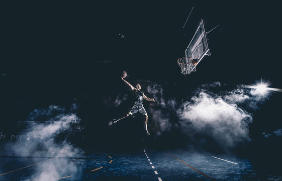 Man jumps playing basket in stadium indor.