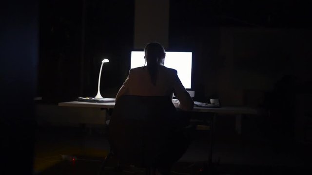 Businesswoman in her office at night working late.