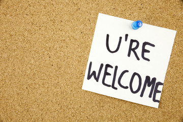 You Are wellcome sign written on sticky note pinned on pinboard