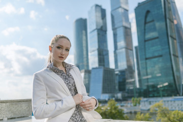 Fototapeta premium Outdoors portrait of young woman in white jacket.