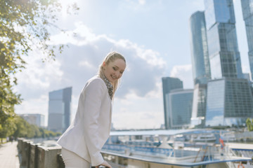 Outdoors portrait of young woman in white jacket.