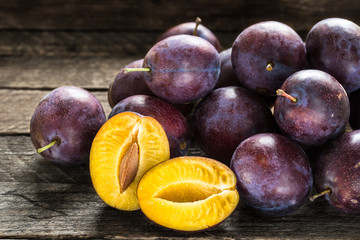 Fresh blue plums on wooden table