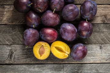 Fresh blue plums on wooden table