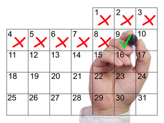 Hand marking a single day with a green checkmark after severeal bad days