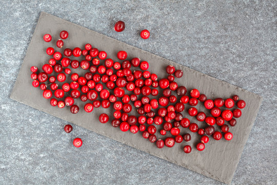 Fresh red cranberries on slate, top view