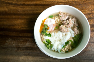 Instant Noodles with Pork Chops and egg in white bowl and Plate on wooden table.