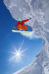 Snowboarder jumping against blue sky