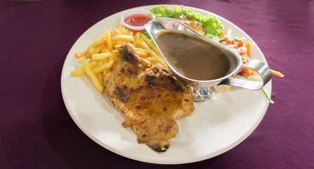chicken grill set with black pepper sauce,potatoes fries and salad on white plate