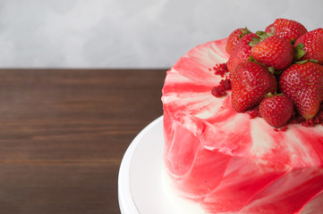 Cake red velvet with whipped red cream, fresh strawberries on dark wooden table. Picture for a menu or a confectionery catalog. Close up.