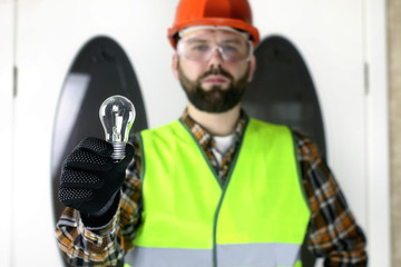 The man in a helmet holding a light bulb