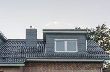 Dach eines Hauses mit Schornstein und Gaube