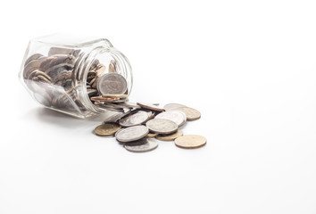 coins spilling from a money jar on white background