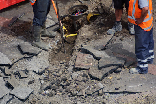 Road Workers Digging With Shovel