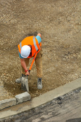 Road worker spreading new gravel