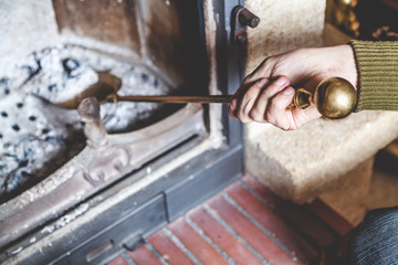 Cleaning  fireplace. Hand holding  shovel with ash