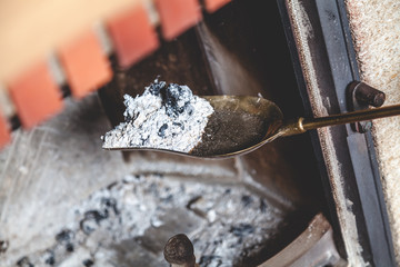 Ash from fire lay extinguished on brass blade