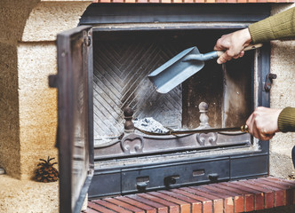 Cleaning fireplace. man pours ashes of  blades in blade