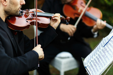 Man in black suit plays the violin