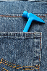 A toy plastic hammer in a back pocket of a denim