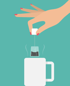 Making a tea concept. Woman's hand holding tea bag above a mug