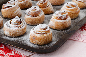 Fresh baked cinnamon rolls on steel baking tray. Homemade cinnamon buns for breakfast