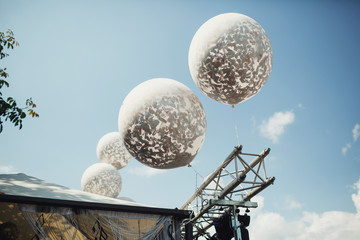 Large silver balloons hang in the air outside