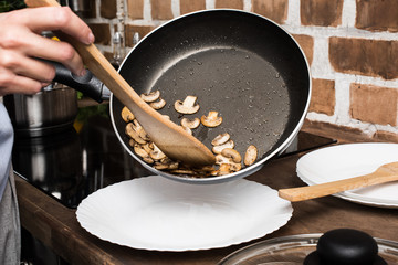 woman cooking mushrooms for dinner