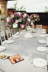 Round pink bouquets stand on the white dinner table