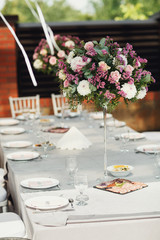 Round pink bouquets stand on the white dinner table