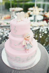 Pink birthday cake with little doll and silver notes