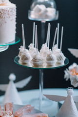Fototapeta na wymiar Little white chocolate balls on sticks served on a glass dish