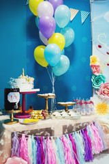 Birthday candy bar with cookies and lemonade decorated with colorful balloons
