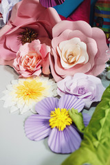 Pink and white paper flowers lie on the floor