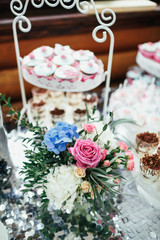 Bouquet of pink rose, blue hydrangea stands on the candy bar