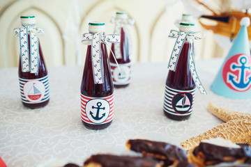 Bottles with cherry lemonade decorated with boats and anchors