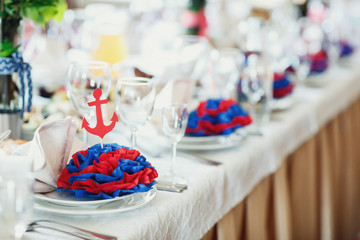 Blue and red serviette with paper anchors served on the dinner plates