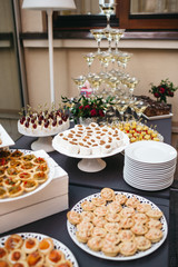 Black dinner table served with white dishes with snacks