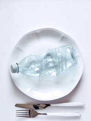bottiglia di plastica pronta da mangiare  un rifiuto plastica in una tavola apparecchiata per il pranzo, sfondo bianco