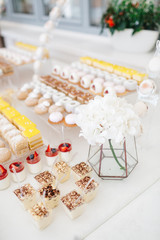 Glasses with berries stand before plates with cookies on a dinner table