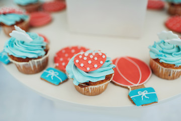 Cupcakes with blue cream and red decor