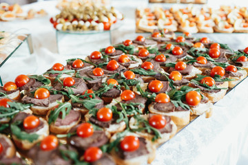 Breads with paste and cherry tomatoes on a glass dish