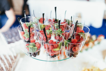 Cups with berries and mint on white dish
