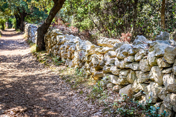 Fototapeta na wymiar Stone rock fence or gabion and road or footpath.